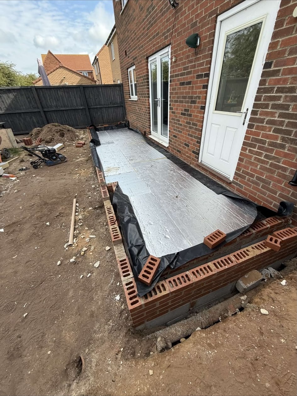 Patio base preparation alongside a house