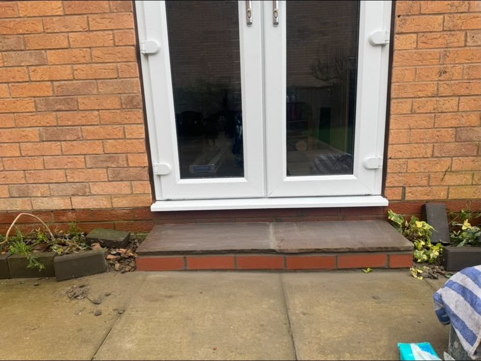 Finished doorstep detail below white French doors
